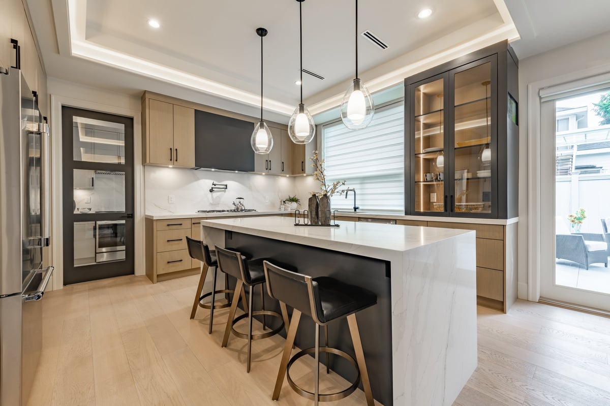 Modern kitchen with white countertops, wooden cabinets, and pendant lighting