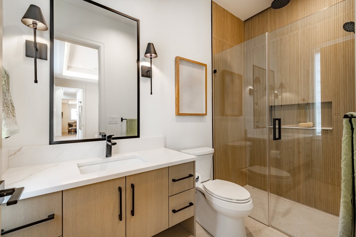 Remodeled bathroom in DuPage County with walk-in shower, frameless glass, and double vanity