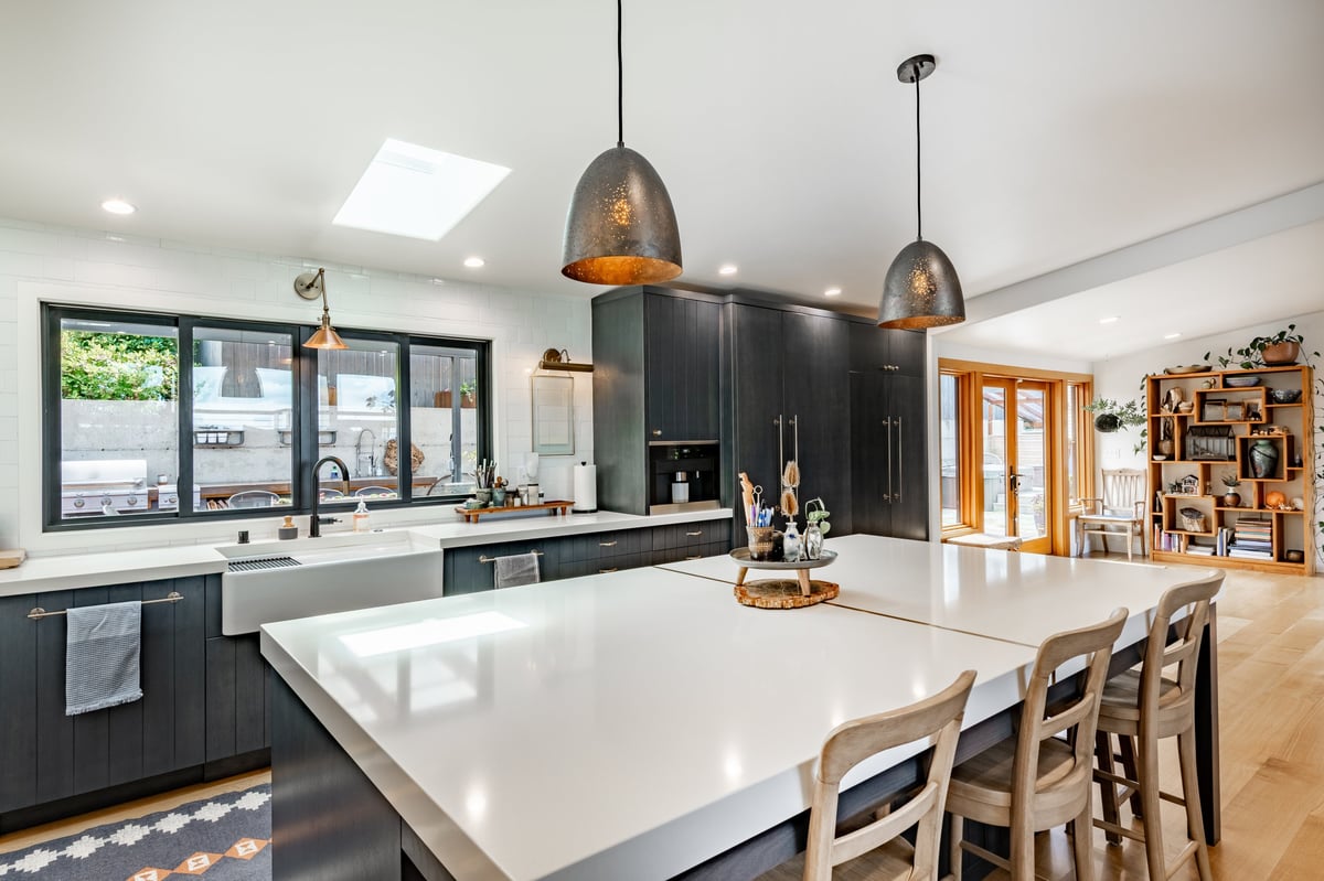 Modern kitchen with custom cabinetry, stone countertops, and elegant lighting