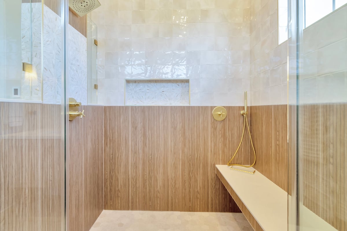 Modern walk-in shower with tiled walls and bench seat