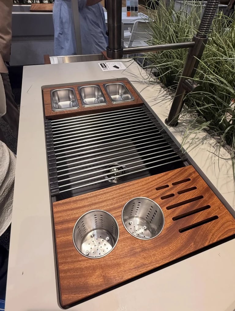 Luxury kitchen sink with wood trim, stainless steel grates, and dual basins on display at outdoor showroom