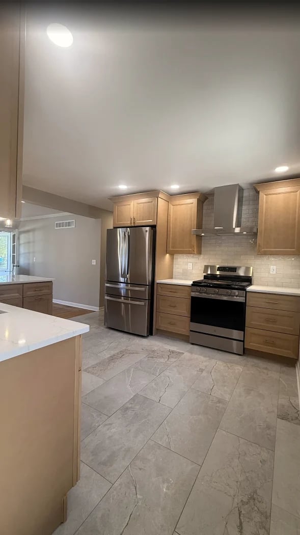 Modern kitchen with oak cabinets, stainless steel appliances, granite countertops, and tile flooring with island seating